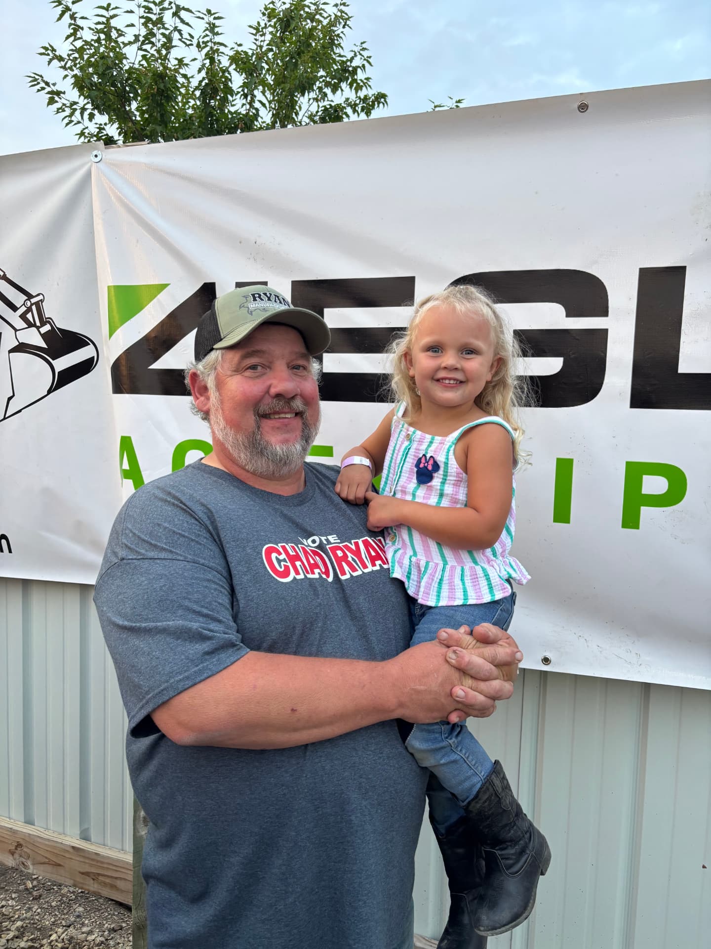 Chad Ryan holding his granddaughter at a community event in Goodhue Minnesota.